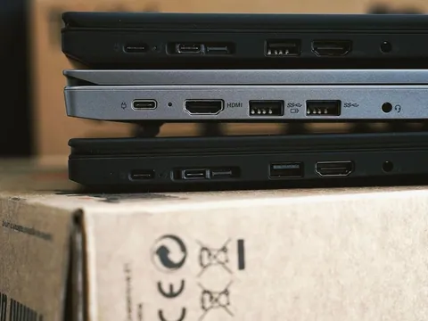 Three closed laptops stacked on cardboard boxes